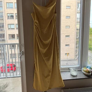 Gul långklänning från Adoore - Säljer min balklänning från förra året!💛Den är ifrån Adoore, har ett mjukt satinliknande tyg och en figurnära passform med en liten slits och drapering i midjan. Älskar den sååå men kommer inte till användning. Den är uppsydd cirka 3 cm, passade mig perfekt med klackar (blev då 165-167). Klänningen är i st. 42 men sitter mer som en 38/40. Har endast använt en gång på balen 2024, pris kan diskuteras.