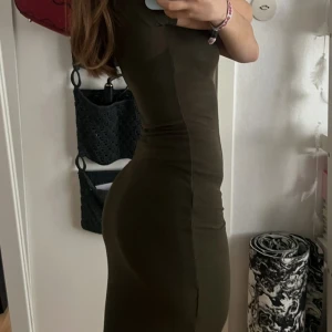 Olivgrön ribbad klänning från H&M🩷  - Säljer en tight olivgrön ribbad klänning från H&M. Klänningen har korta ärmar och en slimfit passform. Storlek xs 🫶