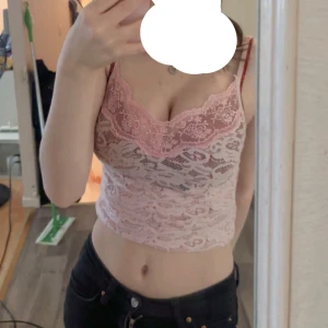 Rosa spetsig croppad linnetopp - Säljer en söt ljusrosa croppad linnetopp med spetsdetaljer och tunna axelband. Toppen har ett romantiskt mönster och är perfekt för varma dagar eller lager på lager. Skriv privat om du vill ha fler bilder och priset kan diskuteras💓