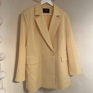 BikBok blazer gul - Blazer från BikBok. Strl XL/42. Oanvänd med mjukt ljusgult tyg. Perfekt för vårig med professionell look.