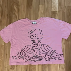 Rosa t-shirt med karaktär från The Simpsons - Rosa t-shirt med tryck från Zara. T-shirten har en större i storleken och kortärmad. Använd fåtal gånger, myckey bra skick. 