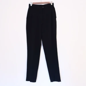 rosner kostymbyxor strl 36 - Svarta kostymbyxor, märke rosner, hög midja, ingen stretch, två fejkfickor bak, två riktiga fickor fram. Mått: 70cm runt midjan, 104cm långa. Kan ta fler bilder och mått vid intresse! 