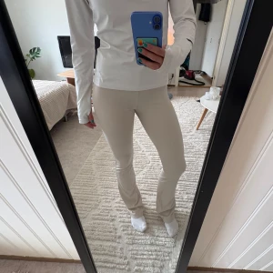 Beige ribbade byxor från H&M Divided - Säljer ett par beige ribbade byxor från H&M Divided i storlek XS. Byxorna har en tight passform och är stretchiga med bootcut. Perfekta för en avslappnad och stilren look.