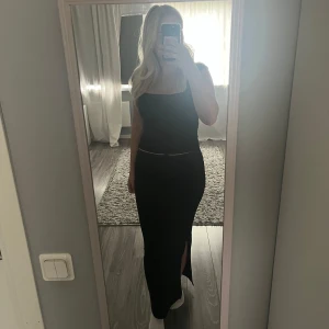 Svart långklänning med slits - Säljer en svart kjol med tight passform och slits på sidan. Perfekt för dig som gillar minimalistisk stil. Aldrig använd