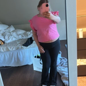 Rosa t-shirt med volangärmar  - Säljer en söt rosa t-shirt med volangdetaljer på ärmarna. En perfekt sommar blus, som inte är för uppklädd eller nedklädd. Så du kan ha den till allt