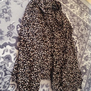 Leopardmönstrad skjorta från KappAhl - Säljer en snygg leopardmönstrad skjorta från KappAhl i storlek S. Skjortan har långa ärmar, klassisk krage och knäppning framtill. Perfekt för dig som vill sticka ut med ett djurmönster🤍🏵
