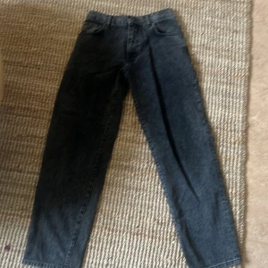 Mörkgrå jeansbyxor från Woodbird - Säljer ett par mörkgrå jeansbyxor från Woodbird i modellen Slim Black Jeans. Klassisk femficksdesign, raka ben och normal passform. Jeansen är tillverkade i ekologiskt material och har en snygg tvättad finish.