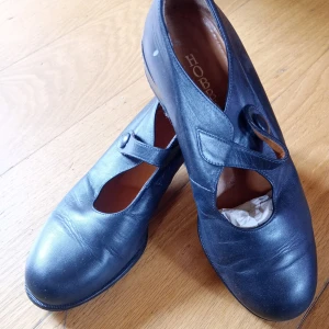 Svarta söta skor - Svarta skor från Hobbs med rund tå och bred klack. Skorna har en rem över foten med knappdetalj. Vintage och coola, Storlek 37 1/2 