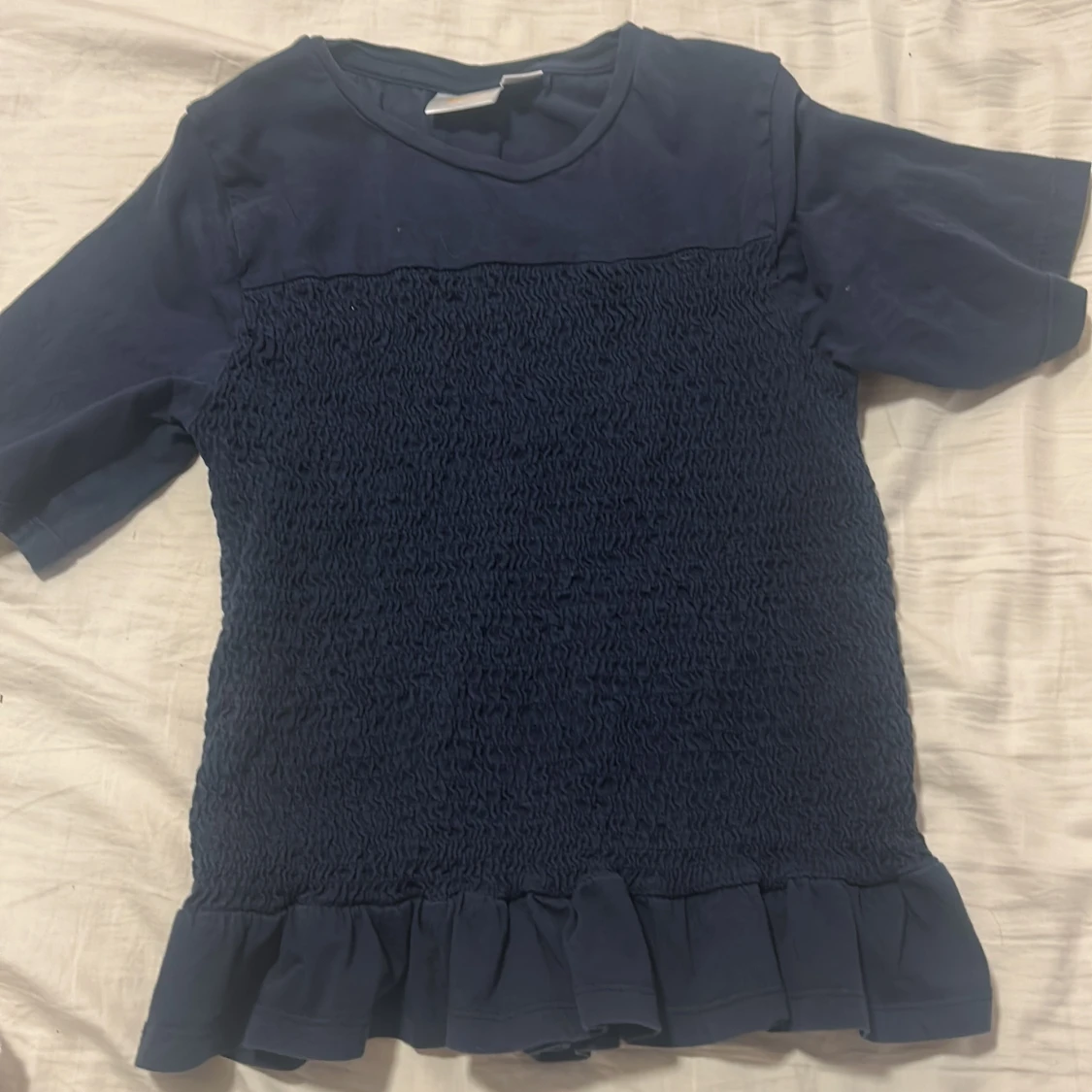 Mörkblå topp med volangkant. Använd ett få tal gånger