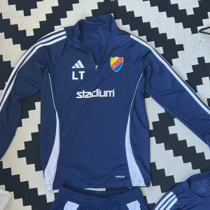 Tränings set från Adidas med DIF-logga - Mörkblå överdelar, träningsbyxor och två par t shirts från Adidas med vita ränder längs sidorna och DIF-emblem på låret. Knappt använda och säljs som ett set 4 grejer för 500kr. 