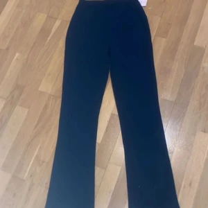 Svarta vida byxor - Säljer ett par svarta byxor med hög midja och vida ben. Perfekta för en stilren och avslappnad look. Byxorna har en klassisk passform och är enkla att matcha med olika toppar.