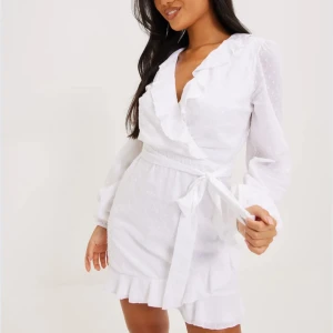 Vit omlottklänning med volang - Säljer denna klänningen som man ej kan köpa längre! Den är använd en gång, vilket var på min grundent, sedan har den blivit tvättat och höngd i garderoben!💗Superfint skick, inga skavanker. Passar till skolavslutning, grundent, student!🤍Nypris 499kr