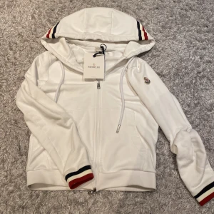 Moncler tröja - En vit moncler tröja som är i är i mycket bra skick den är i storlek S tveka inte på att fråga om du har frågor eller bara skriv om du vill ha fler bilder