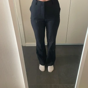 Svarta kostymbyxor från BikBok - Snygga svarta kostymbyxor från BikBok i storlek 36. Byxorna har en klassisk design med hög midja och raka ben. Perfekta för en stilren look.