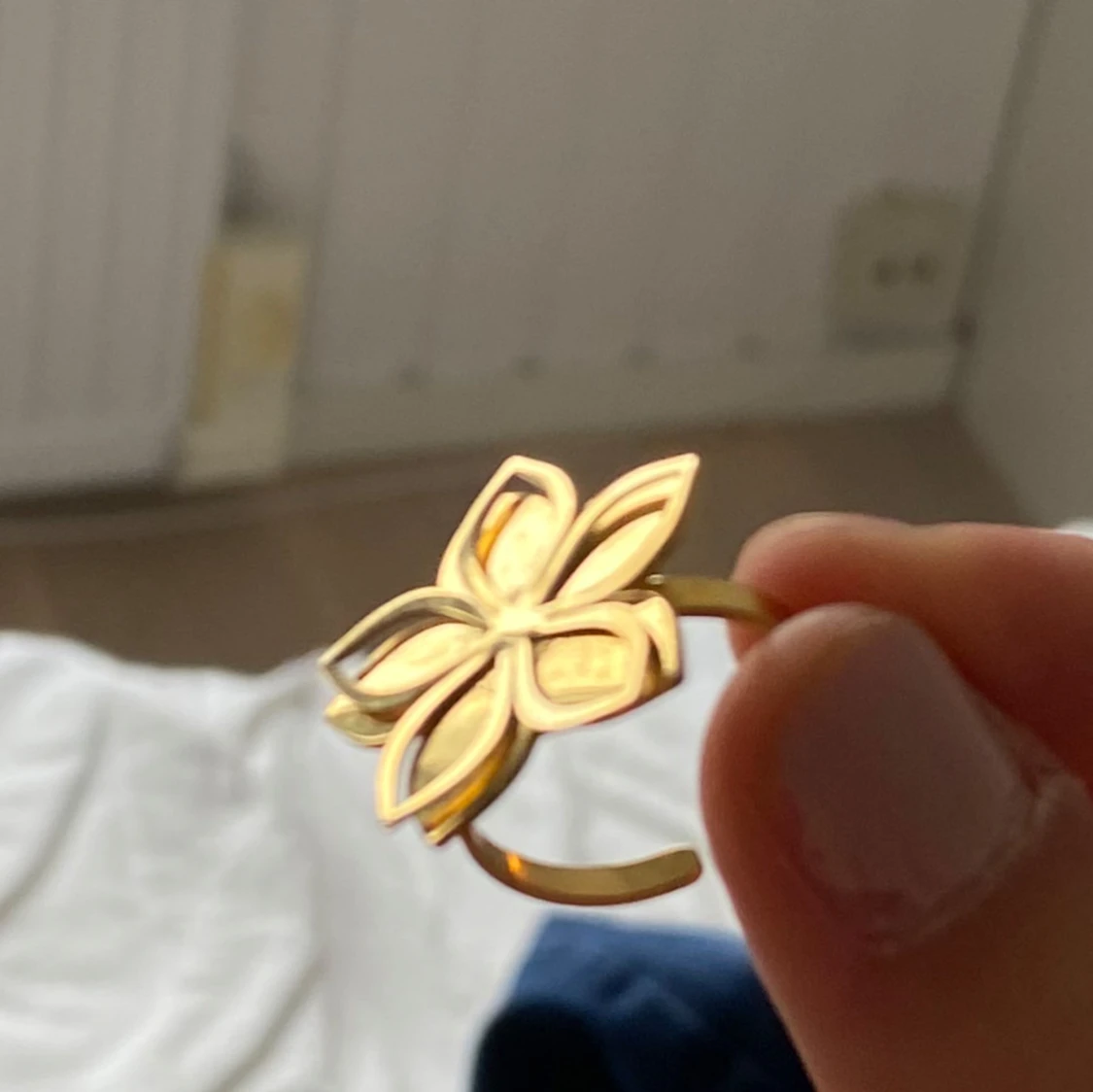 Guldfärgad ring med blomdesign