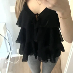Svart volangtopp från Zara - Säljer en svart volangtopp från Zara. Verkkigen super fin men aldrig andvänt så lika bra att jag säljer! Alltså helt nytt skick inga fel. 