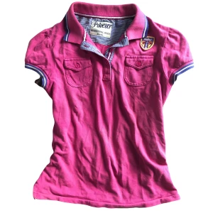 Rosa pikétröja från Pikeur - Snygg kortärmad rosa pikétröja, snygga detaljer, fickor osv. Skicka om du vill ha fler bilder! Märket står som ”Pikeur”. Liten missfärgning på insidan vid etiketten