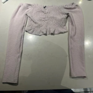 Ljusrosa offshoulder topp från BikBok - Säljer en söt ljusrosa offshoulder topp från BikBok. Toppen är croppad och har långa ärmar.