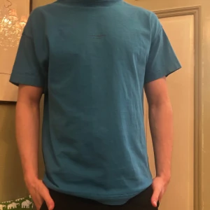Blå t-shirt från Acne Studios - Snygg blå t-shirt från Acne Studios med diskret logga på bröstet. Perfekt för en stilren och avslappnad look. Tillverkad i mjukt material för extra komfort.
