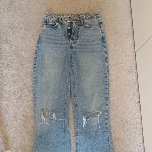 Blå jeans från bikbok  - Blå jeans från bikob med hål vid knäna. Liten fläck på ett av benen men ingenting som syns jätte mycket. Skulle säga storlek 34!! Skirv för fler bilder. Pris kan diskuteras!!!! 