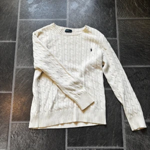 Vit stickad tröja från Ralph Lauren - Säljer en stilren kräm vit stickad tröja från Ralph Lauren. En skön tröja perfekt nu till sommaren! Tröjan sitter perfekt mellan 180-185cm 🙌Står XL på tagen men skulle säga att den sitter mer som en M/L