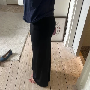 Svart lågmidjad långkjol - Snygg svart Lågmidjad långkjol med en elegant, i jättefint skick!