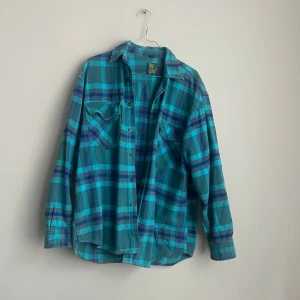 Vintage Blå och grön rutig skjorta från One Way - Säljer en cool blå och grön rutig skjorta från One Way. Skjortan har långa ärmar och knappar framtill. Perfekt för en avslappnad stil. 🌀
