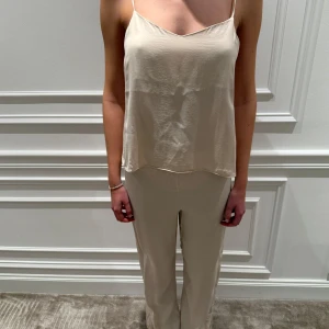 Pyjamas sett från Zara Home - Säljer detta super gulliga pyjamas sett från Zara Home. Toppen har tunna axelband och en öppen rygg med knytning. Perfekt för varma dagar eller som ett lager under en kavaj. Använt fåtal gånger, är alltså i bra skick! Nypris 1000kr