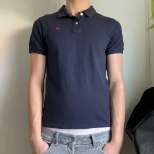 Mörkblå pikétröja från Morris - Säljer denna snygga mörkblå pikétröja från Morris med klassisk krage och två knappar, som är perfekt till sommaren. Använd ett fåtal gånger, storlek S. Nypris ligger på 749 kr, lägg bud eller köp direkt