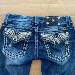 MissMe jeans - Snygga blå MissMe jeans med unika broderade detaljer på bakfickorna. Jeansen har en låg midja och flared modell.