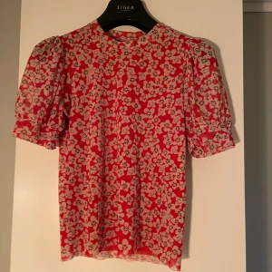  blus från Soaked in Luxury - Säljer en söt röd blus med blommigt mönster från Soaked in Luxury. Perfekt för att liva upp garderoben med lite färg och mönster!Endast använd vid ett tillfälle!! Skriv vid frågor❣️❣️