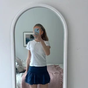 Mörkblå kjol med broderade detaljer - Säljer en mörkblå kjol med broderade blommönster och volangdetaljer. Perfekt för en somrig look. Elastisk midja för bekväm passform. Färgat om hemma men finns inga ojämnheter av färg💙