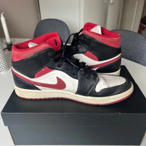 Nike Air Jordans i svart, röd och vit - Säljer ett par klassiska Nike Air Jordans i svart, röd och vit. Skorna har slitage inuti vid hälen. Skriv vid funderingar!