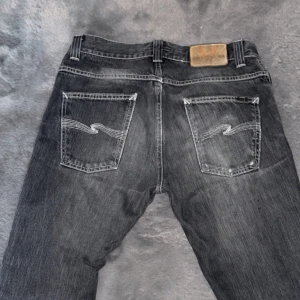 Mörkgråa Nudie Jeans  - Jag säljer ett par mörkgråa Jeans från Nudie som ej passar längre. De är perfekta för en avslappnad stil. De är använda ca 2-3 gånger 🙌😁
