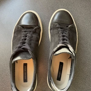 Svarta sneakers från Sneaky Steve - Säljer dessa snygga svarta sneakers från Sneaky Steve med en stilren design. Skorna har en ovandel av Mocka och är väldigt lika Lanvins.