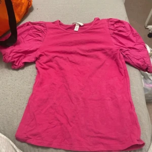 Rosa topp från H&M - Säljer en söt rosa topp från H&M med puffiga korta ärmar. Perfekt för en färgglad look. 💖