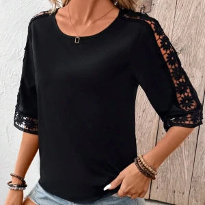 Svart blus med spetsdetaljer - Snygg svart blus med trekvartsärmar och vackra spetsdetaljer på ärmarna och axlarna. Perfekt för en stilren look.