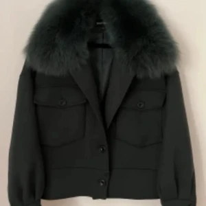 Svart kappa med pälsdetalj - Jättefin grön meotine kappa med pälsdetalj vid kragen. Perfekt nu till våren👍🏻 om du har några frågor så är det bara att skriva 💕inte använd alls mycket (ungefär 4 gånger ) eftersom att den va för liten för mig. 