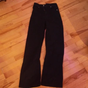 Svarta byxor från Divided - Snygga svarta byxor från Divided i storlek XS. Byxorna har en klassisk design med 4 fickor och knappgylf. Perfekta för en stilren look.