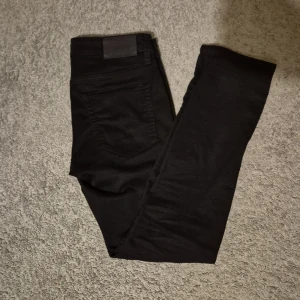 Svarta slim jeans från Jack & Jones - Snygga svarta slim jeans från Jack & Jones, modell Glenn. Perfekta för en stilren look med en smal passform. W=29, L=30. Hör av dig om du har några funderingar. Pris är diskuterbart!