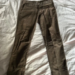 Bruna byxor - Snygga bruna byxor med normal passform och midwaist. Perfekta för en stilren look. Byxorna har knappar och dragkedja framtill.