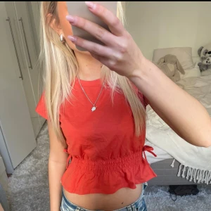 Orange topp med knyte - Säljer denna organge topp med knytning i sidorna. Har du någon fråga är det bara att höra av dig🫶🏻