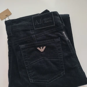 Svarta jeans från Armani Jeans - Snygga svarta jeans från Armani Jeans med klassisk design. De har en stilren look med en metallogo på bakfickan och en knappgylf. Perfekta för en stilren och elegant outfit.