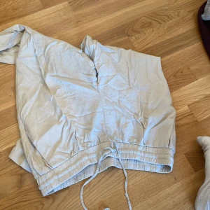 Beige byxor med snörning - Säljer ett par beige byxor med hög midja och snörning i midjan. Byxorna har en avslappnad passform och en bakficka. Perfekta för en stilren och bekväm look. Aldrig använts pga av storlek.