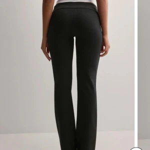 Svarta kostymbyxor - Snygga svarta kostymbyxor med låg midja och bootcut-stil. Byxorna har en stilren design med samma design som på bilden förutom knapparna,  passar perfekt till vardags eller mer uppklätt.❤️galet bekväma men måste tyvärr sälja då dem har blivit för små😢storlek 36/S och passar någon som är 160-165 cm lång⭐️