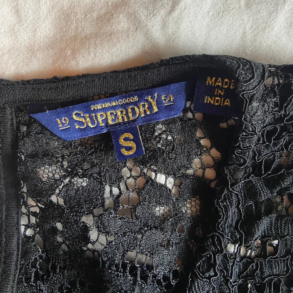 Säljer en elegant svart spetsblus från Superdry. Blusen har ett vackert blommönster och är perfekt för en stilren look. Fick från min mamma för något år sen så finns inte kvar på marknad längre ❤️ Spetsen är väldigt tjock och ordentlig så extreamt svårt att tröjan ska skadas eller gå sönder. Blusen är i storlek S från Superdry 😚😚. Yläosat.