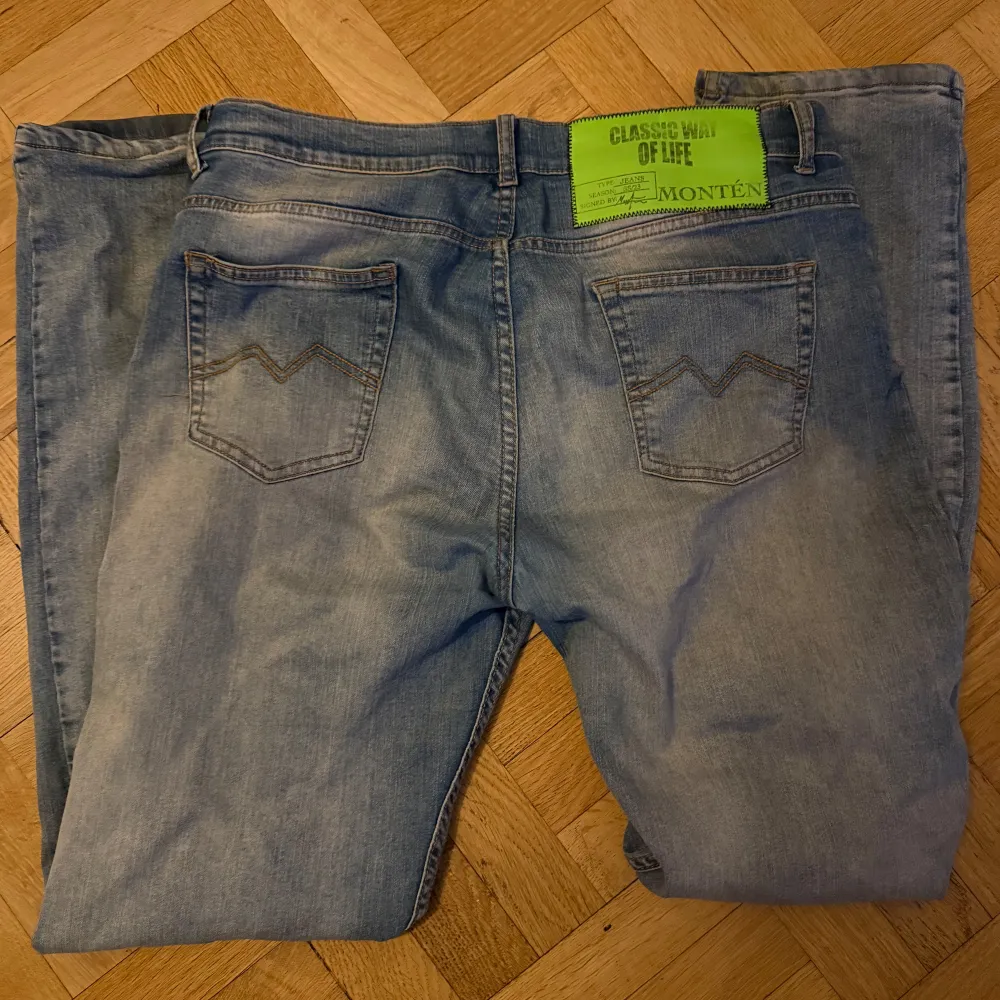 Snygga blå jeans från Monten med en klassisk femficksdesign. De har en ljus tvätt och raka ben, perfekt för en avslappnad stil. Jeansen har en knappgylf och bälteshällor.. Farkut & Housut.