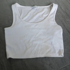 Vit ribbad linnetopp från FB Sister - Säljer en vit ribbad linnetopp från FB Sister i storlek XS. Toppen är ärmlös och har en enkel design som passar perfekt till sommaren. Perfekt för en avslappnad look! Har en fläck på framsidan men kan användas under jacka eller undan annan tröja. Har inte gjort något speciellt för att få bort fläcken så vet int eom det går bort eller inte! 