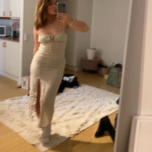 Beige  klänning - Snygg beige klänning med knytning framtill och slits. Perfekt i sommar. 