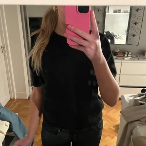 Svart stickad tröja - Säljer en svart stickad tröja med korta ärmar. Perfekt för en stilren look. Tröjan har en rund hals och är gjord i ett mjukt material som känns skönt mot huden. Den är lite nopprig men det är inget en nopprare inte kan fixa!! Köptes för ett tag sen och säljs inte längre ❤️❤️❤️ perfekt till vintern och sommaren, vardag och fest!!!